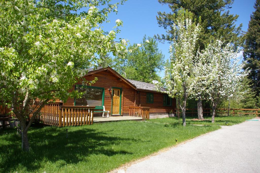 费尔蒙特温泉克里克赛德度假屋的小木屋设有门廊和树木