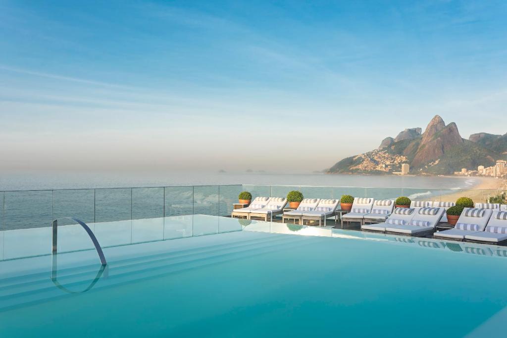 里约热内卢里约热内卢法萨诺酒店的一个带椅子的游泳池,享有海景