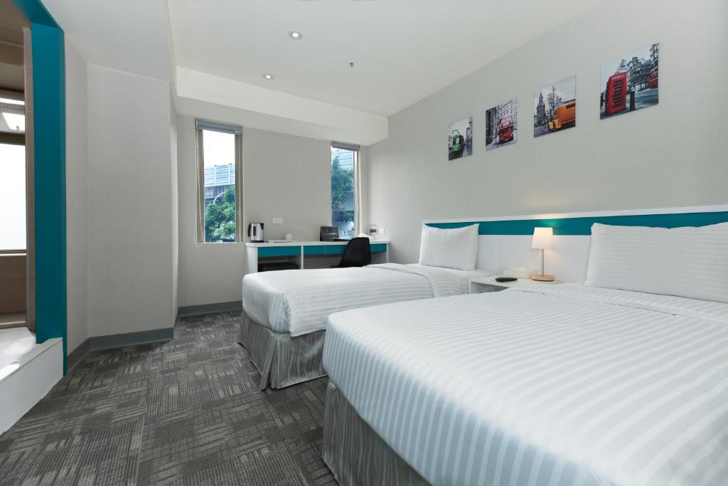 台北久居栈旅店的酒店客房带两张床和两个窗户