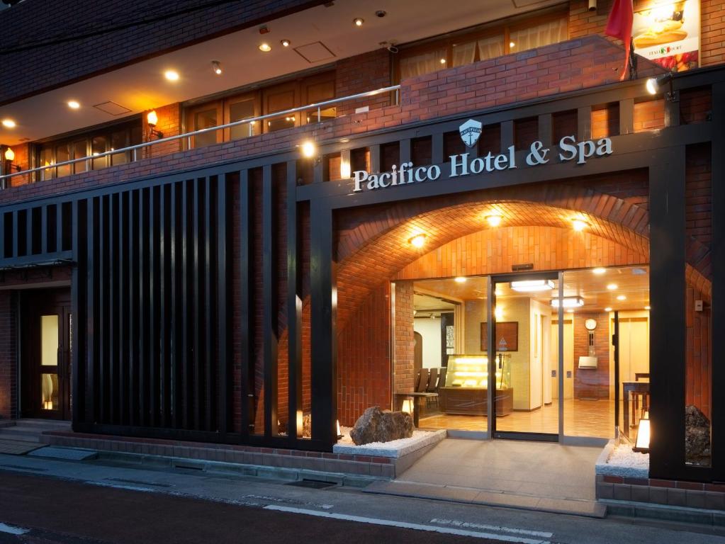 磐城PACIFICO Hotel and Spa的带有旋转酒店和水疗中心的标志的酒店
