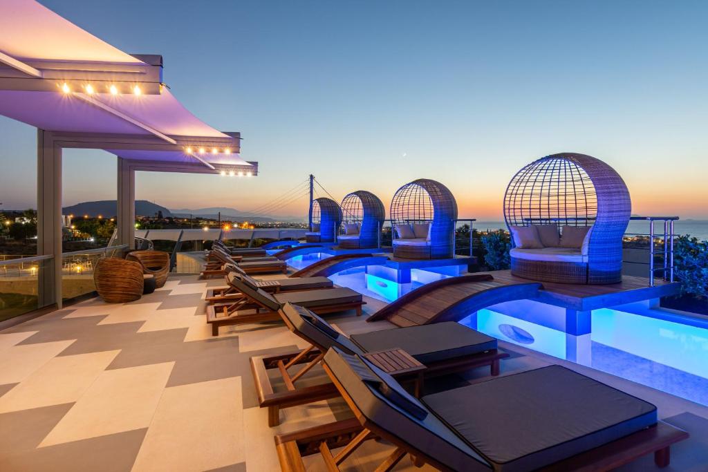 赫索尼索斯Onira Suite Dreams的一座带椅子的建筑屋顶上的游泳池