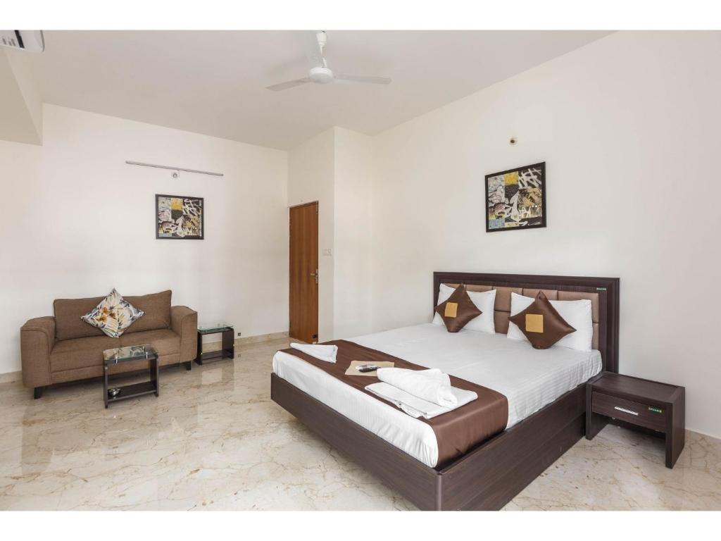 班加罗尔Olive Service Apartments - Koramangala的一间卧室配有一张床和一张沙发