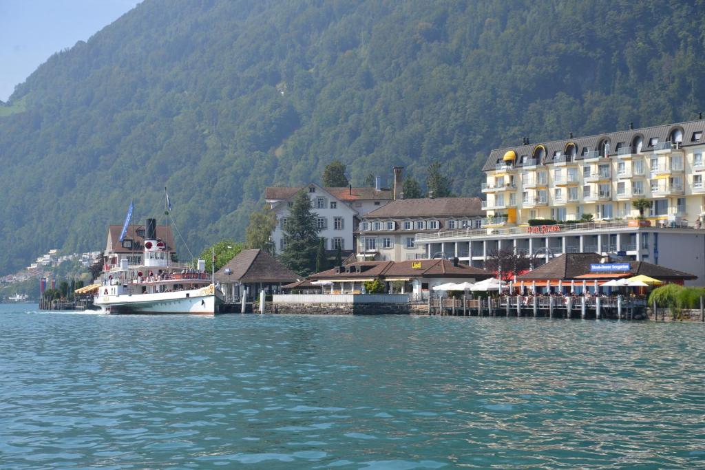 盖尔绍Seehotel Riviera at Lake Lucerne的船停靠在水面上的城镇旁边