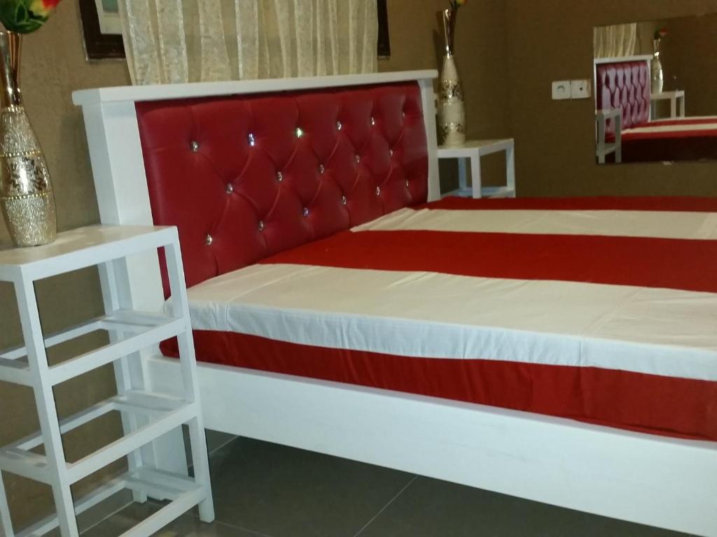 雷霍沃特vacation house יחידת אירוח פרטית רחובות的一间卧室配有红色和白色的床和两张桌子