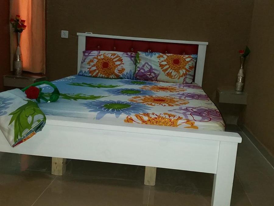 雷霍沃特vacation house יחידת אירוח פרטית רחובות的一张白色的床,上面有色彩缤纷的床单和枕头