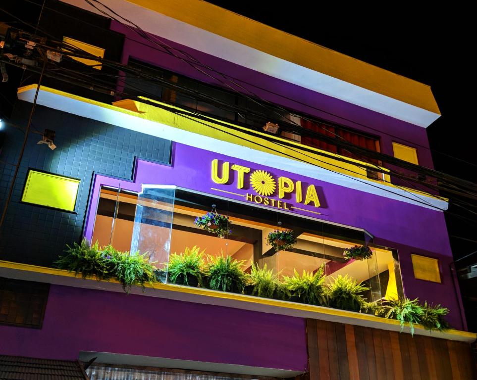 阿帕雷西达Utopia Hostel的带有读utpta酒店标志的建筑