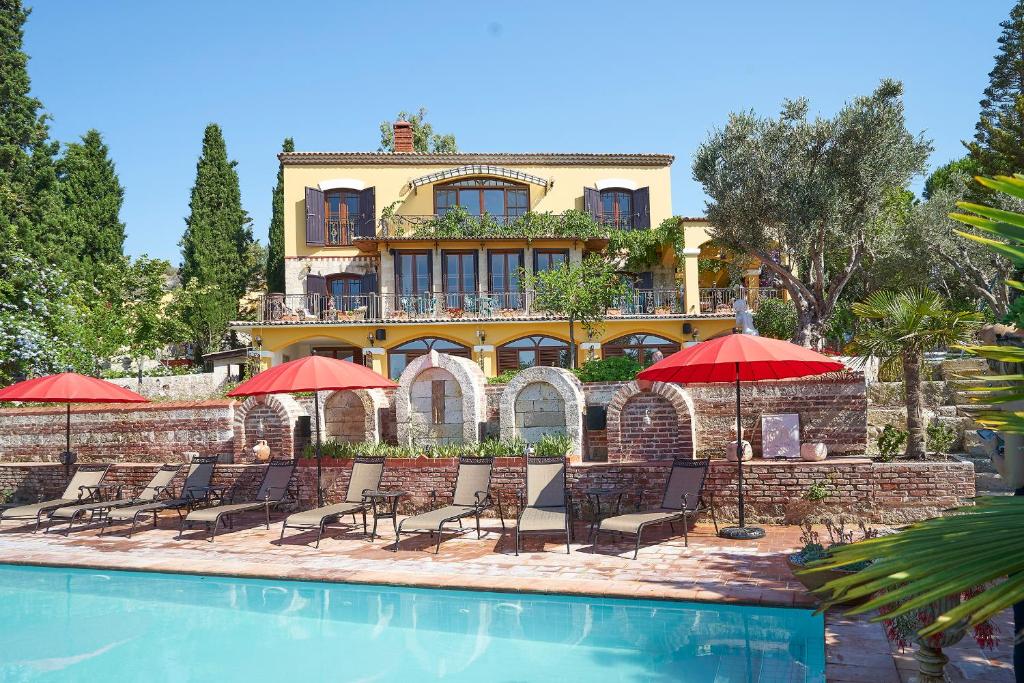 阿拉恰特Villa Taraça Alaçatı Romantik Otel的游泳池旁带椅子和遮阳伞的房子