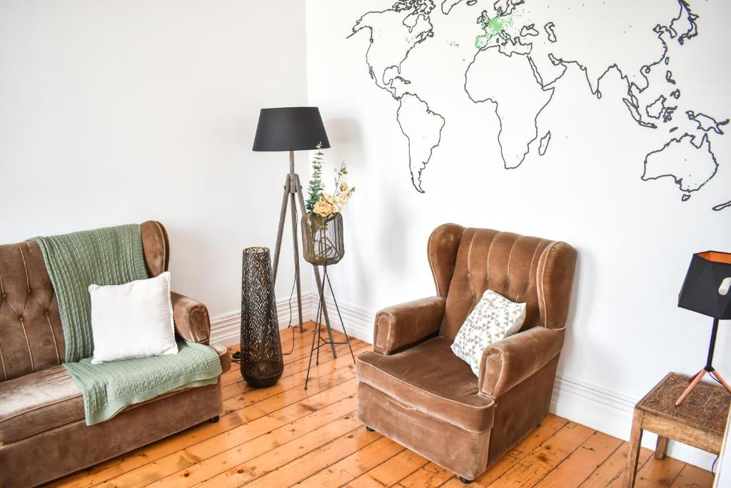大里贝拉A Casa da Cascata的客厅配有两把椅子,墙上挂着世界地图