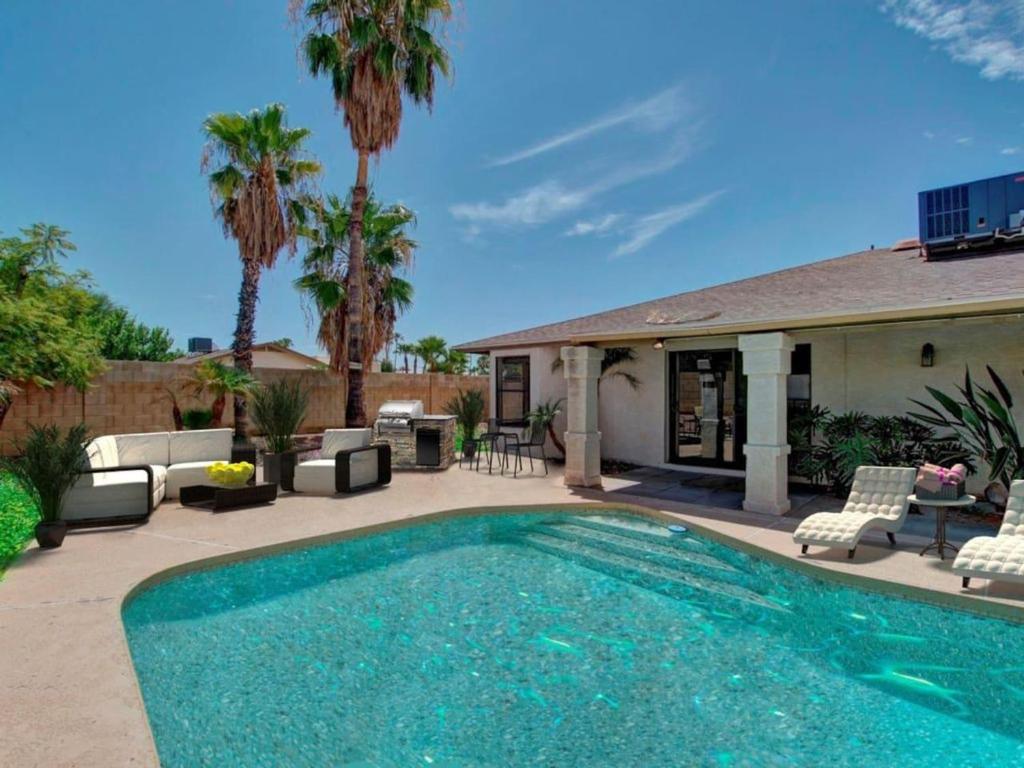 斯科茨Kierland Villa · North Scottsdale Home w/Pool~Walk to Kierland Area的棕榈树屋前的游泳池