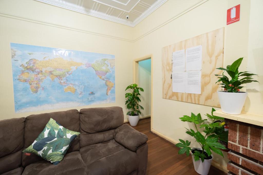 珀斯myOZexp Aberdeen Lodge的客厅配有沙发和墙上的地图