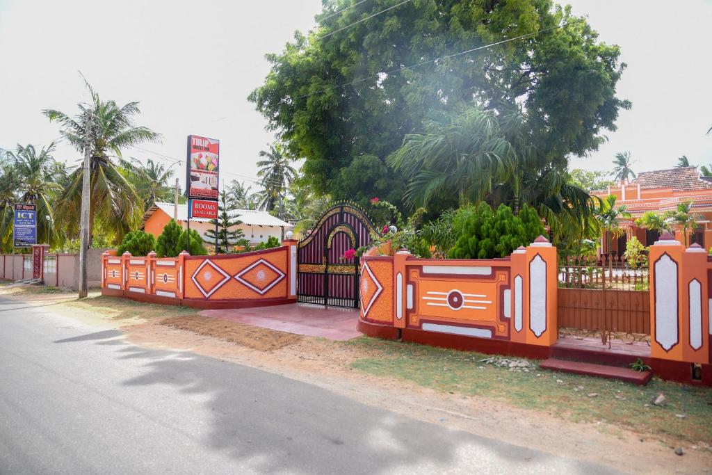 Point Pedro郁金香旅馆的一条橙色的围栏,在道路的一边植有植物