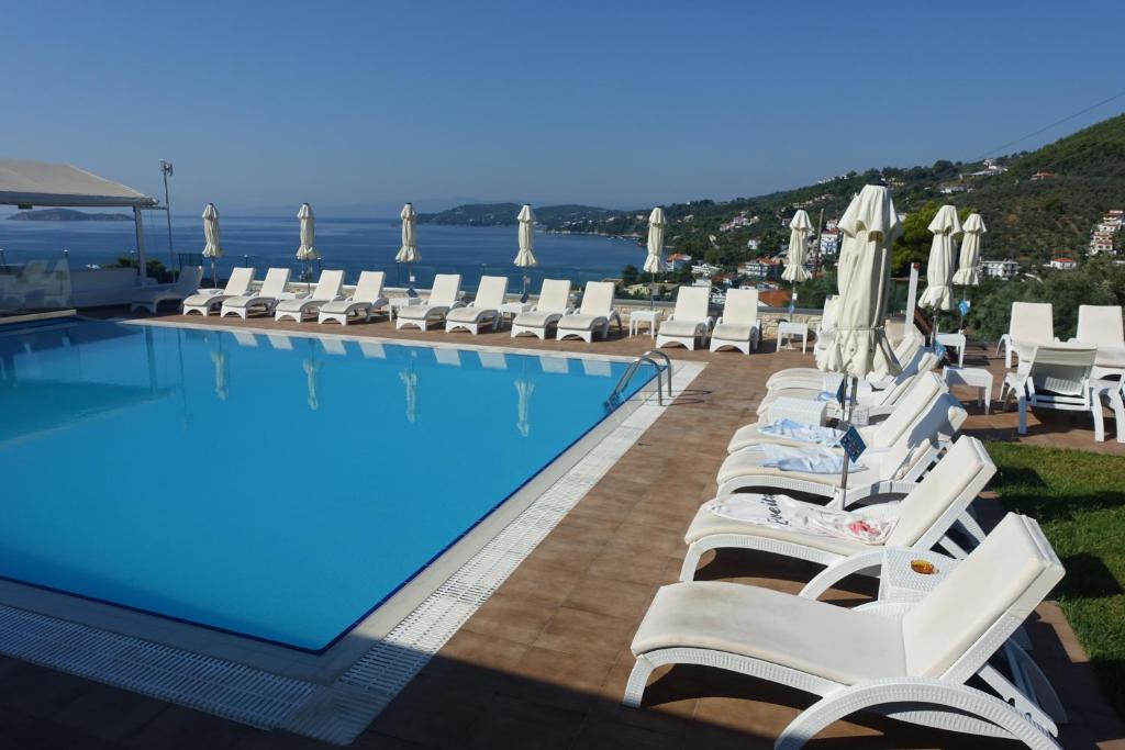 斯基亚索斯镇瑞丽酒店的一个带白色躺椅的游泳池和一个游泳池