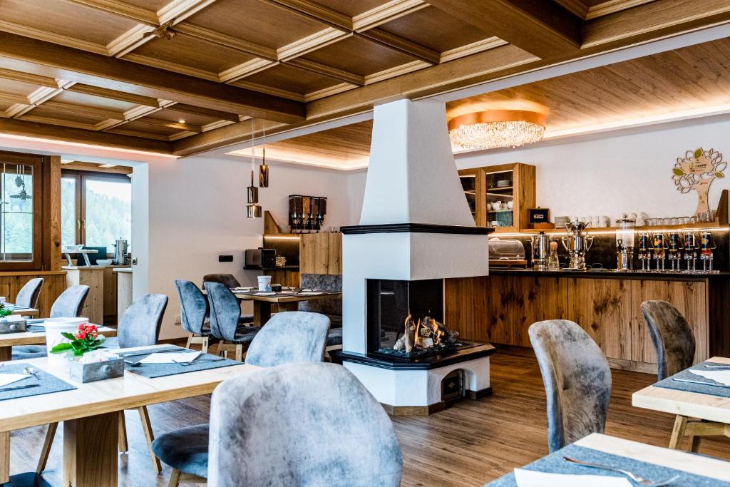 塞尔瓦迪加尔代纳山谷维尔德贝齐早餐酒店及公寓的一间带桌椅和壁炉的用餐室
