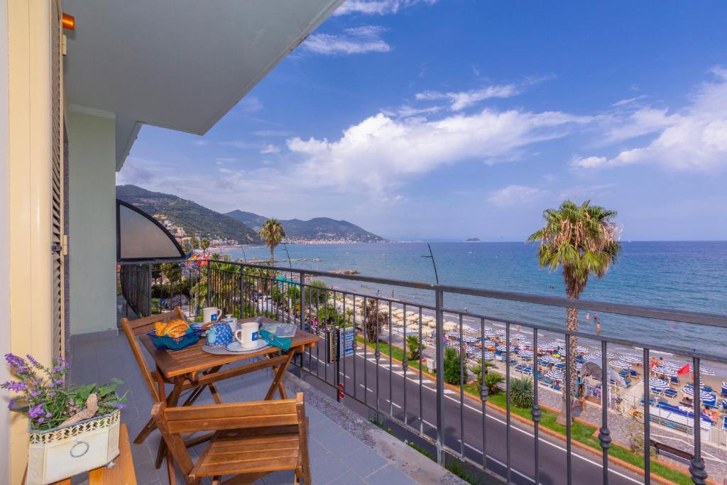 莱圭利亚Laigueglia Beach - Happy Rentals的阳台配有桌子,享有海滩美景