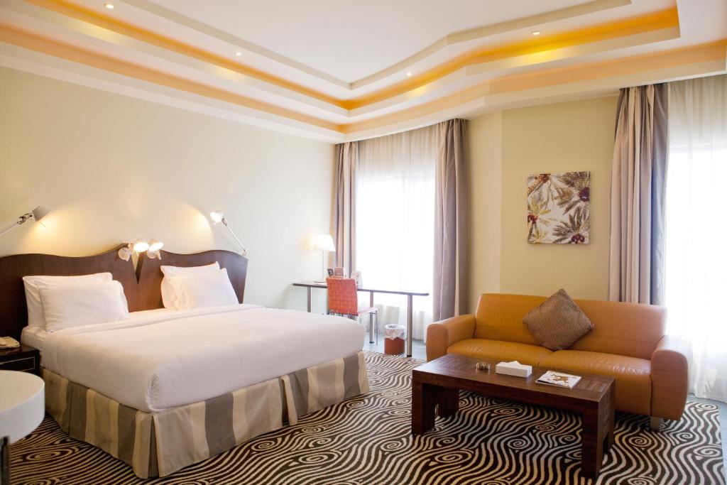 麦纳麦阿尔拉亚套房酒店的酒店客房,配有床和沙发