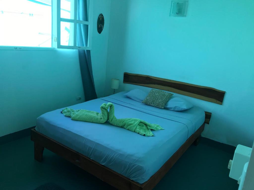 萨玛拉green house two bedrooms的蓝色卧室,配有一张带绿毯的床