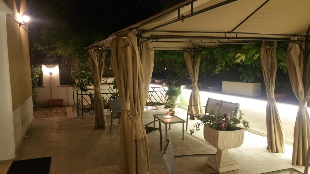 罗马GARDEN HOUSE - Luxury Guest House - Only Self Check in的一个带遮阳伞和鲜花桌的庭院