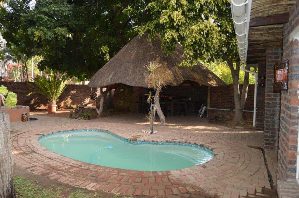 帕拉博鲁瓦Villa Danamara的一座小游泳池,位于带小屋的砖砌庭院内