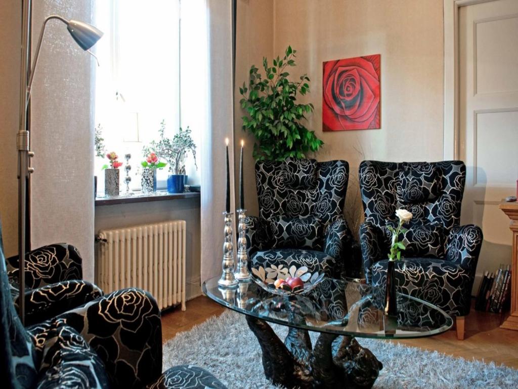 哥德堡艾卡兰达住宿加早餐旅馆的客厅配有两把椅子和一张玻璃桌