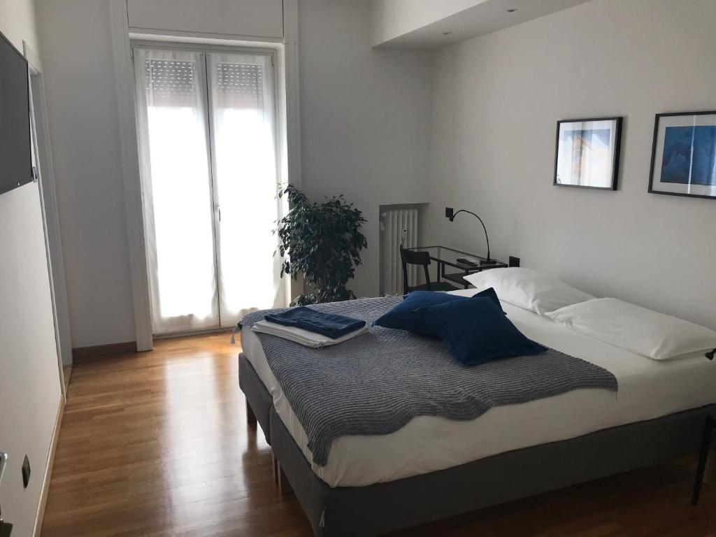 米兰Feel@Home Apartment+Rooms的一间卧室配有一张带蓝色枕头的床。