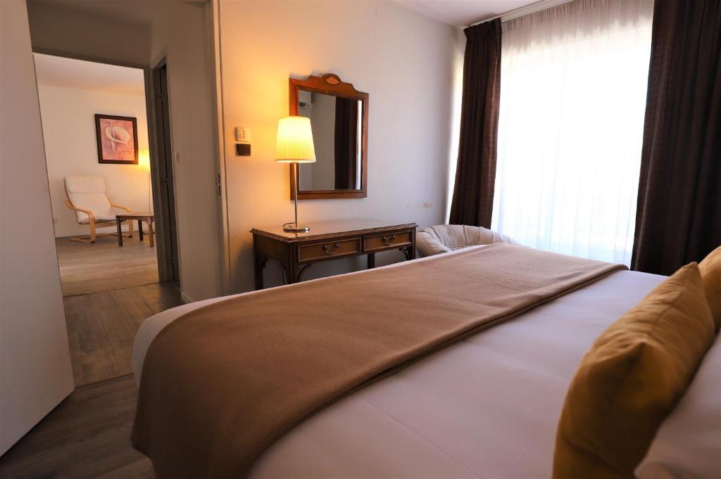 尼姆德图乐里酒店的一间卧室配有一张床、镜子和一张桌子