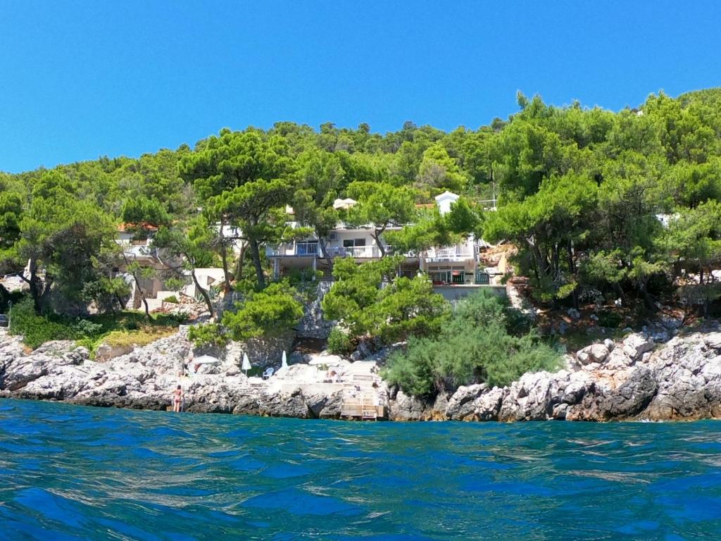 普利兹巴Ratak House的岩石海岸上一座拥有房屋的岛屿