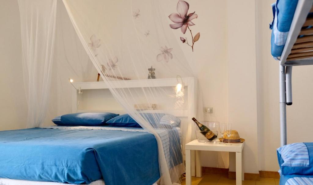圣伊西多罗Colori Salentini Appartamento Sabbia的一间卧室,配有一张带蚊帐的床
