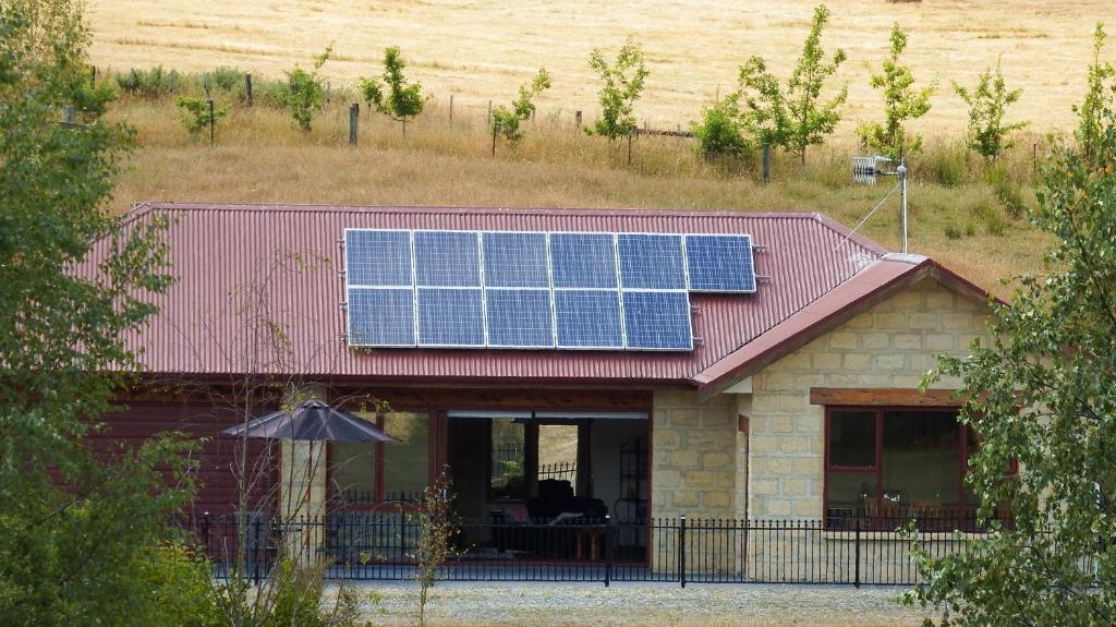 MahanaMahana Farm Cottage的一座房子,屋顶上设有太阳能电池板