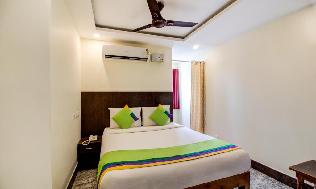 蒂鲁帕蒂Treebo Trend Sls Grand的一间卧室配有一张大床和色彩缤纷的毯子