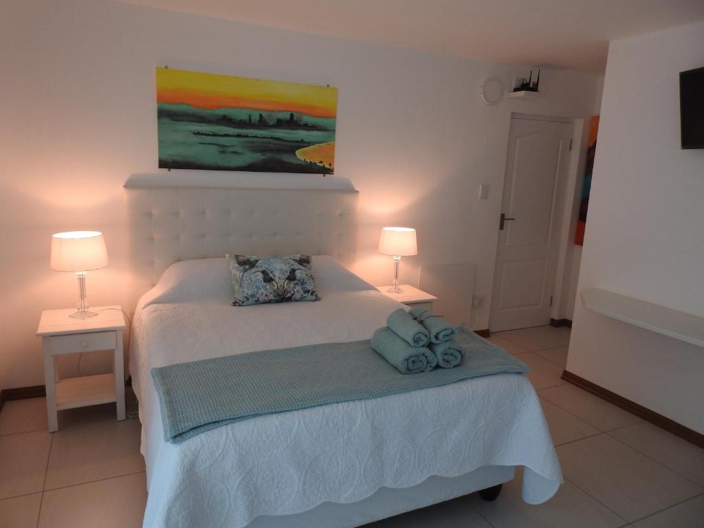 萨尔达尼亚Berg en Dal Accommodation的卧室配有带两盏灯的白色床