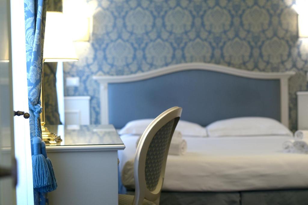 威尼斯科尔特巴罗奇威尼斯套房酒店的卧室配有1张床、1张桌子和1把椅子