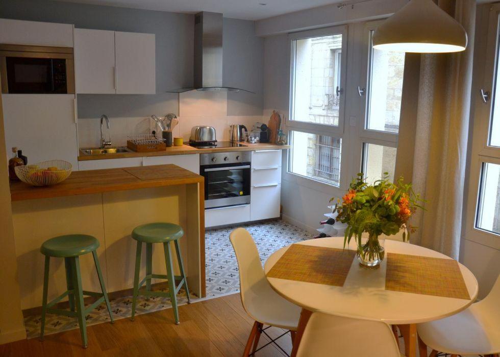 波尔多Burdigala Homes - Appart de Lalande的厨房配有桌椅和鲜花桌