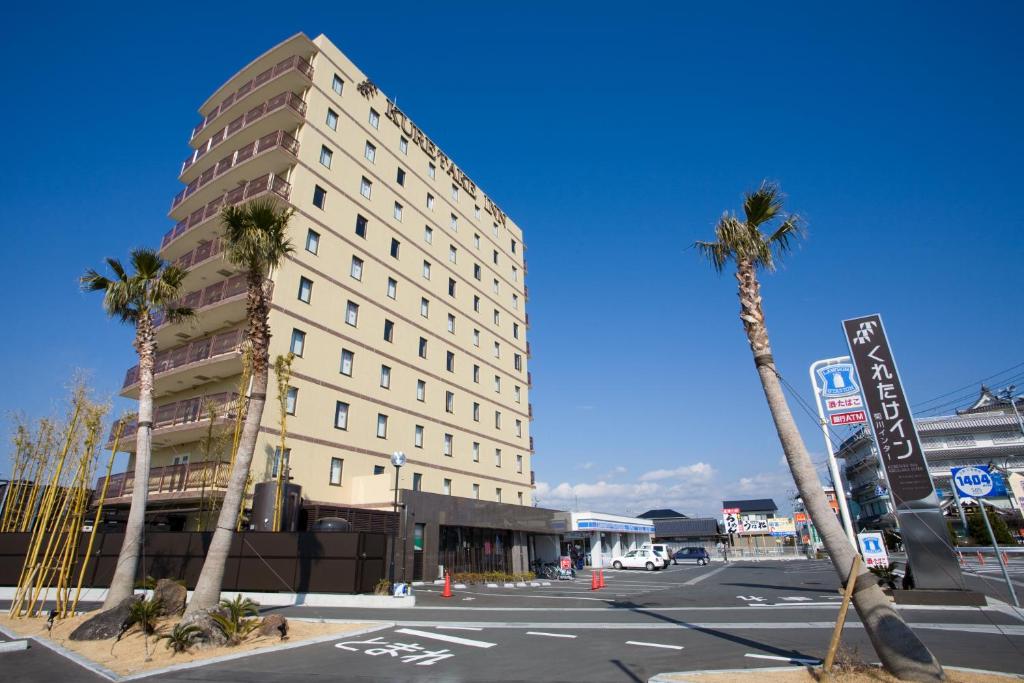 菊川市菊川I.C.吴竹旅馆的一条街道前方有棕榈树的高楼