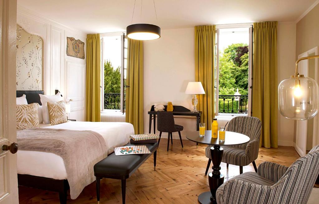 GuéronChâteau Saint Gilles的卧室配有一张床和一张桌子及椅子
