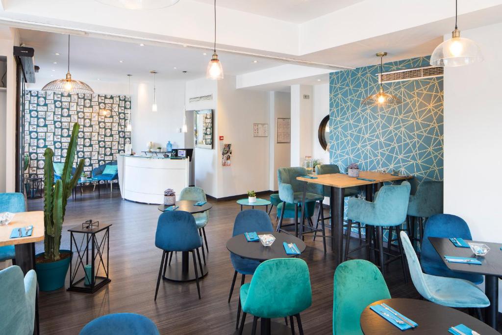 尼斯阿克罗波利斯驿站酒店的一间在房间内配有蓝色椅子和桌子的餐厅
