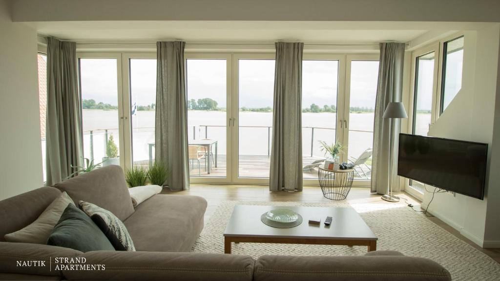 布拉克Luxuswohnung Pazifik WESER WELLNESS WHIRLPOOL的带沙发和大窗户的客厅