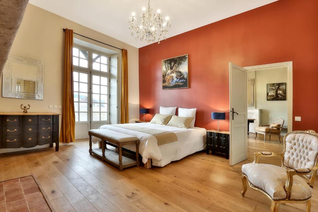 佩里格La Maison des Consuls的一间卧室配有一张大床和一个吊灯。