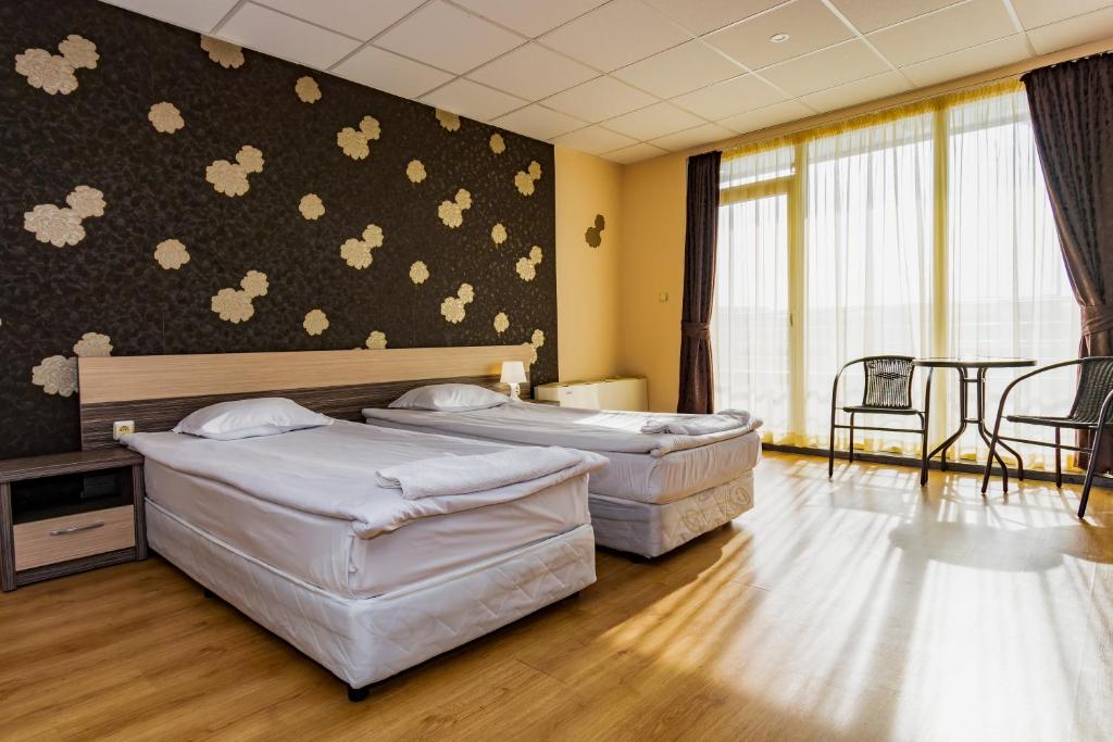 布尔加斯Hotel City的酒店客房设有两张床和一张桌子。