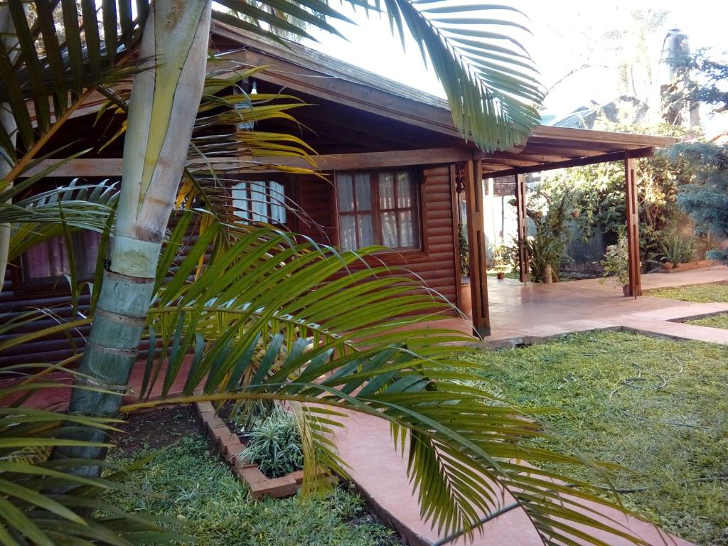 伊瓜苏港IGUAZU CABANAS的前面有棕榈树的房子