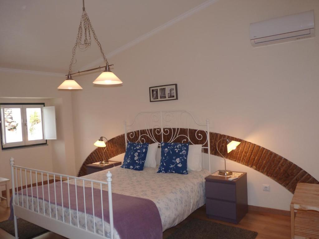 埃武拉Páteo dos Oliveira - Casa dos Serviçais的一间卧室配有一张带蓝色枕头的大床