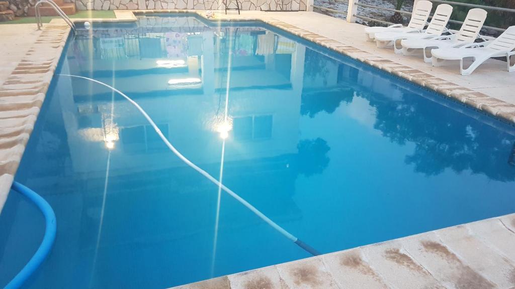 托伦特Calicanto House & Pool的一个带椅子的游泳池,海水蓝色