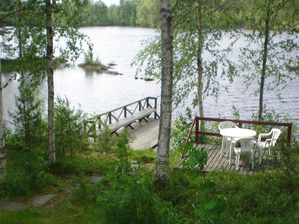 Kosula哈提图维特山林小屋的湖畔木甲板,配有桌椅