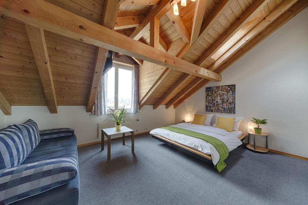 因特拉肯Hotel Blume Interlaken的一间卧室配有一张床和一张沙发