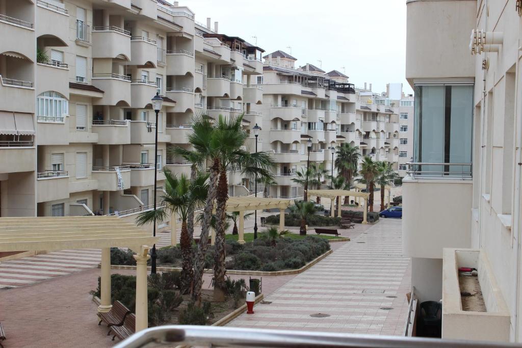阿瓜杜尔塞A 1 minuto de la playa. Aguadulce ( Almería)的从棕榈树建筑的阳台上可欣赏到风景