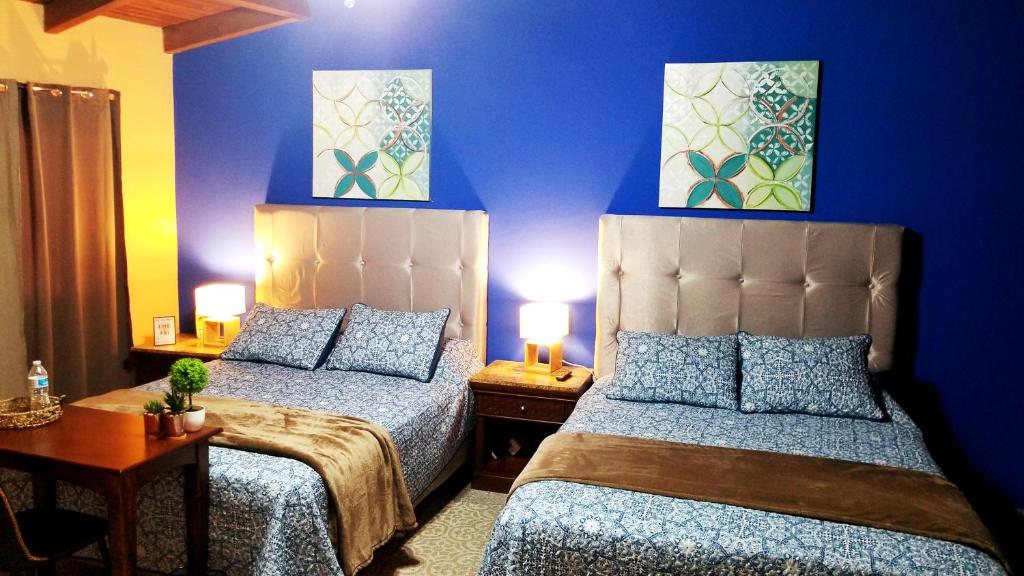 特古西加尔巴Portal los Castaños的蓝色墙壁客房的两张床