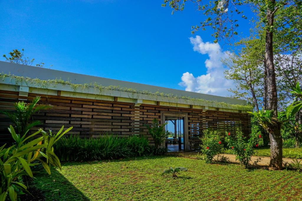 LonggaNaya Matahora Island Resort的一座木质建筑,前面设有花园