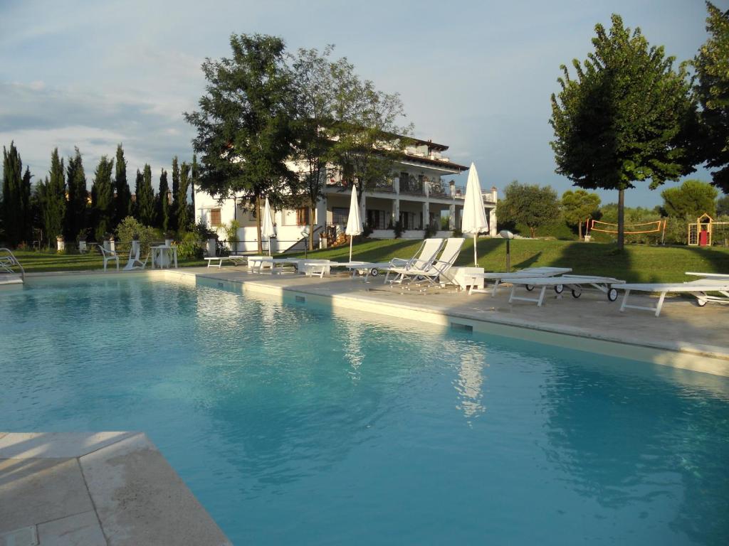 巴蒂帕利亚拉迪奇24号住宿加早餐旅馆的一个带椅子的游泳池和一个背景建筑