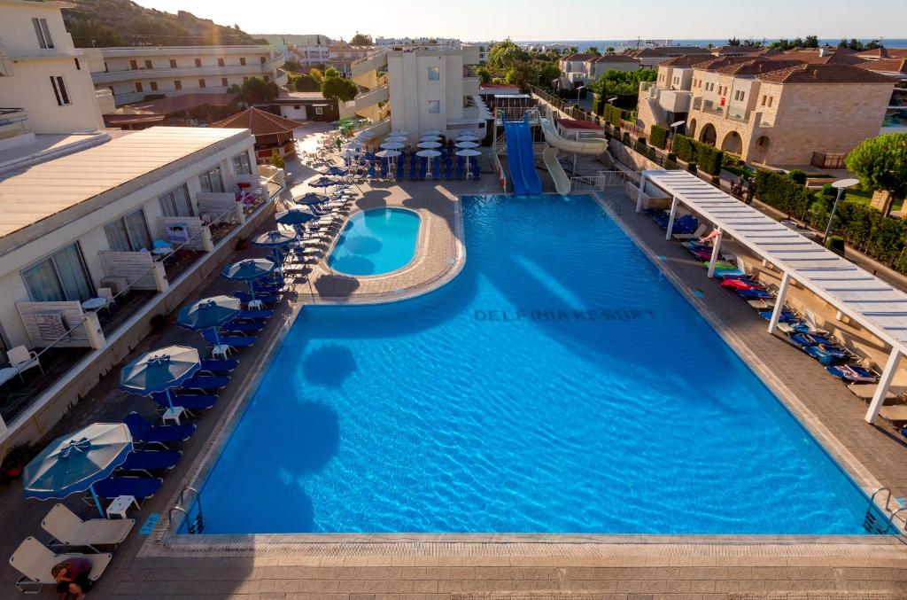 科林比亚Delfinia Resort - All Inclusive的享有酒店游泳池的空中景致,配有椅子和遮阳伞