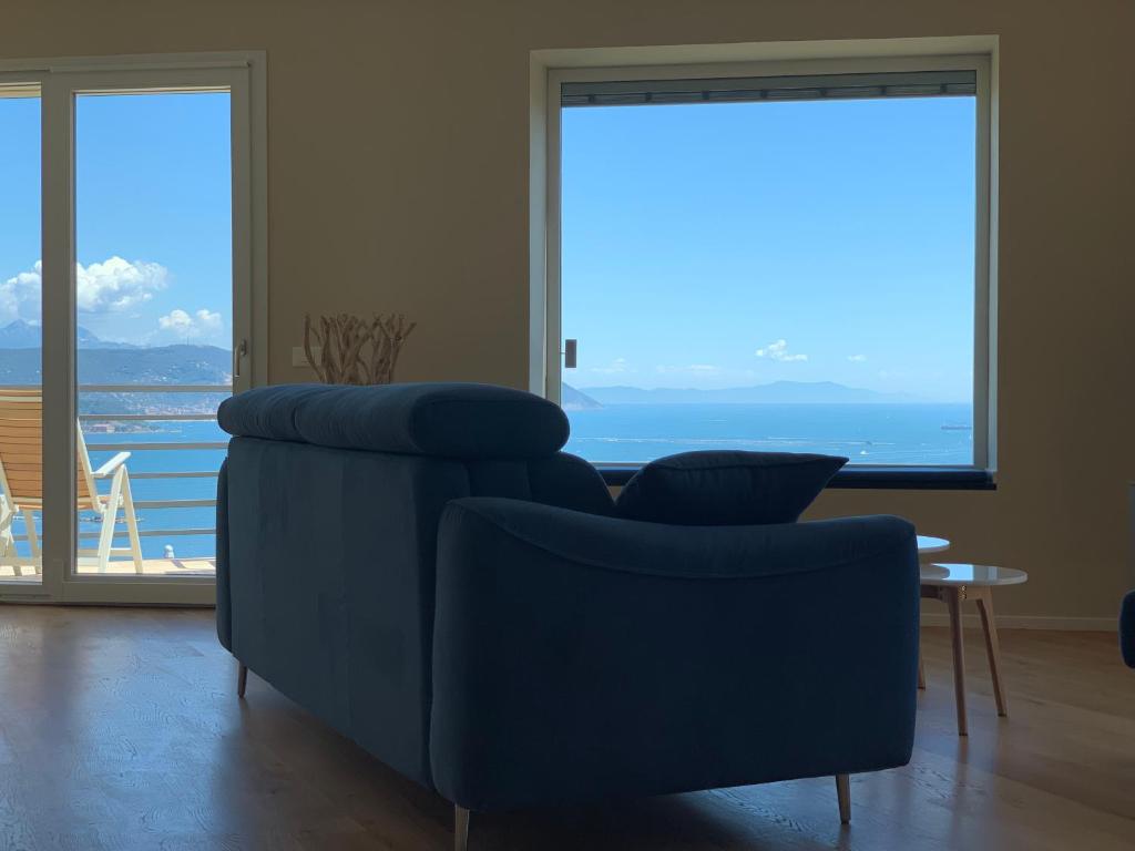 斯培西亚San Giorgio La Litoranea的客厅设有蓝色的沙发和大窗户