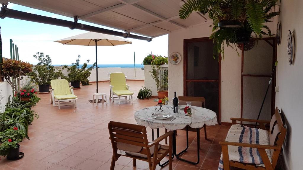 阿格特Ático con gran terraza en el Risco de Agaete-wifi的一个带桌椅的庭院和大海